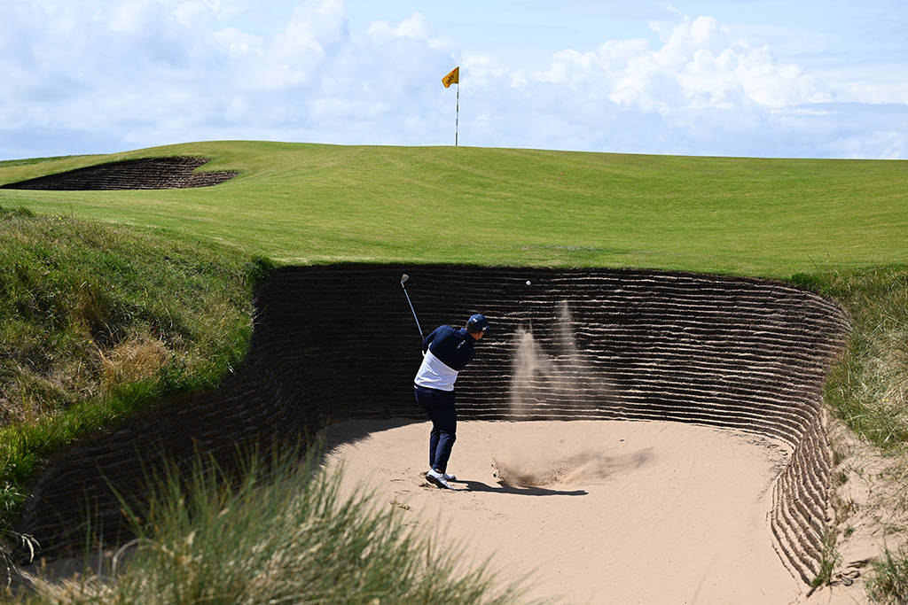 Zach Johnson plays from the cavernous front bunker on the 17th